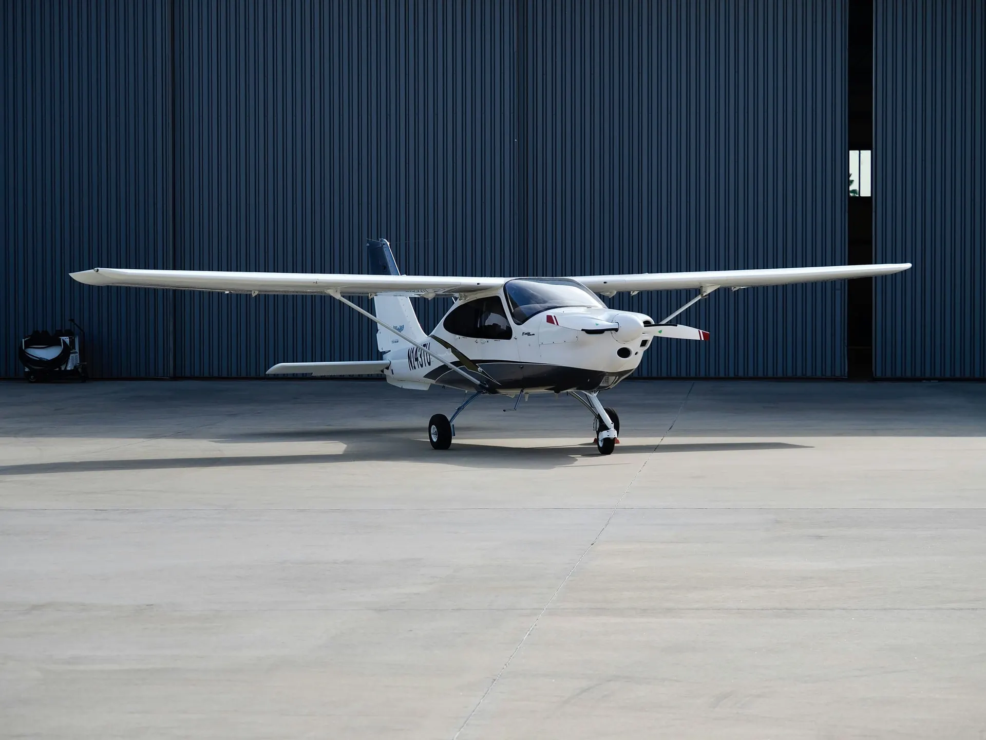 Klein sportvliegtuig op het platform voor een hangar