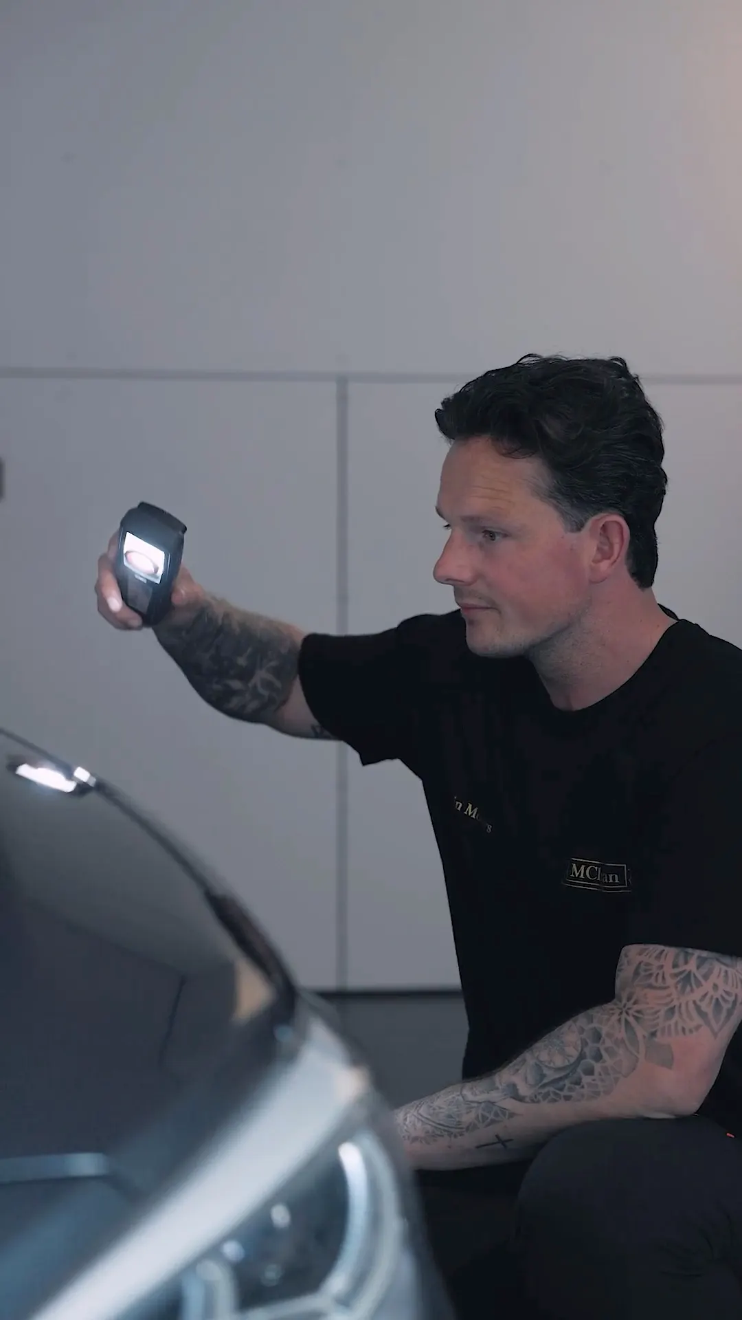 Detailer inspecteert de lak met een lamp