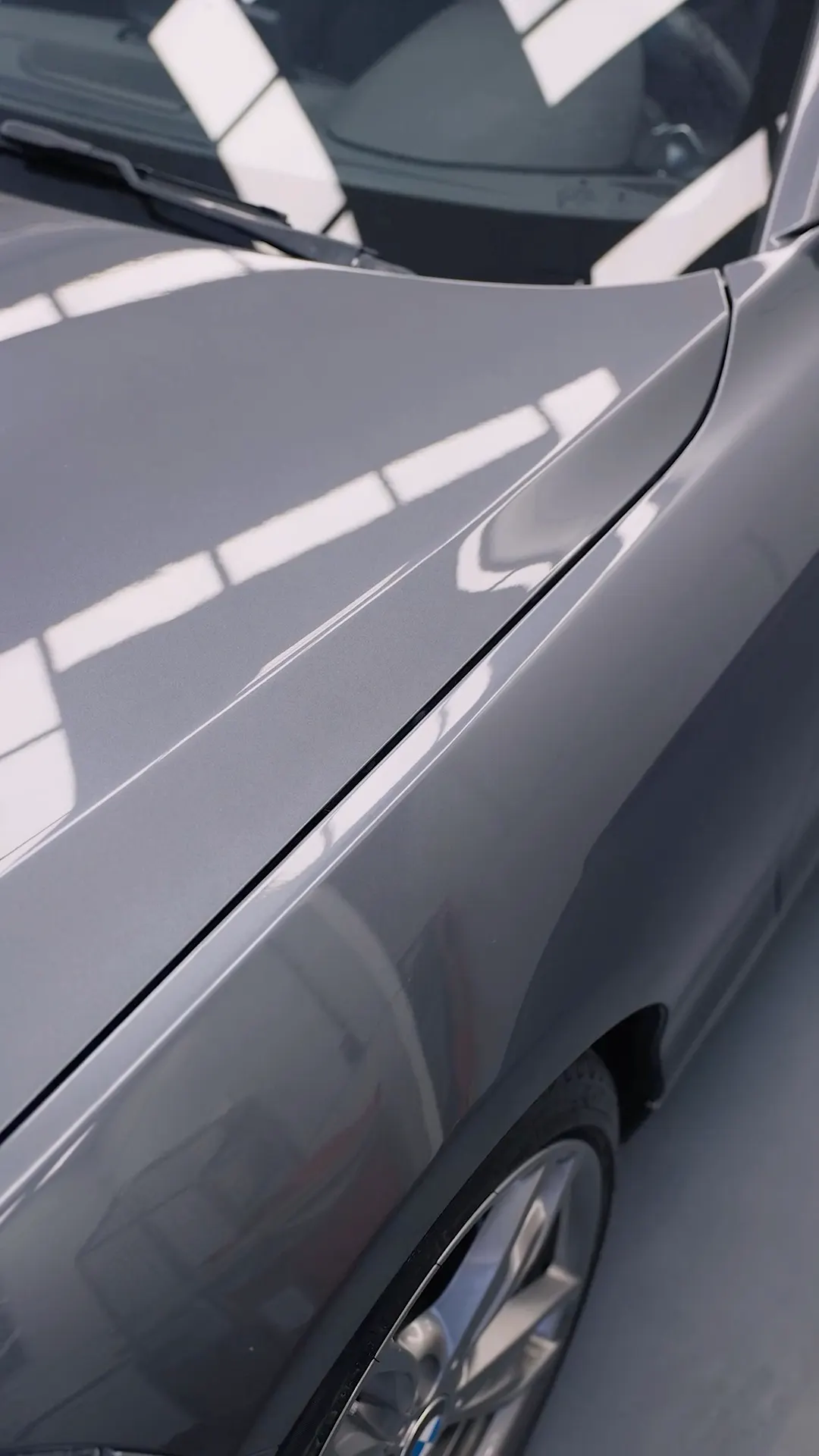 Glanzend spatbord en portier van een grijze BMW in de studio