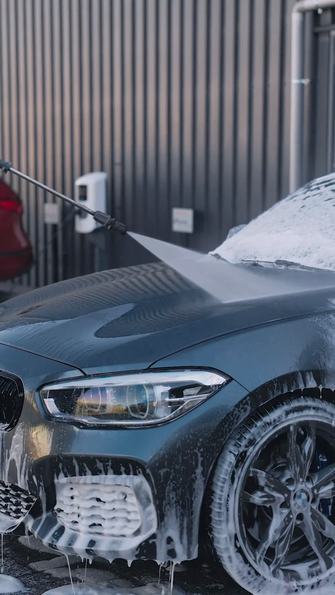 Een grijze BMW wordt ingezeept met een foamlans