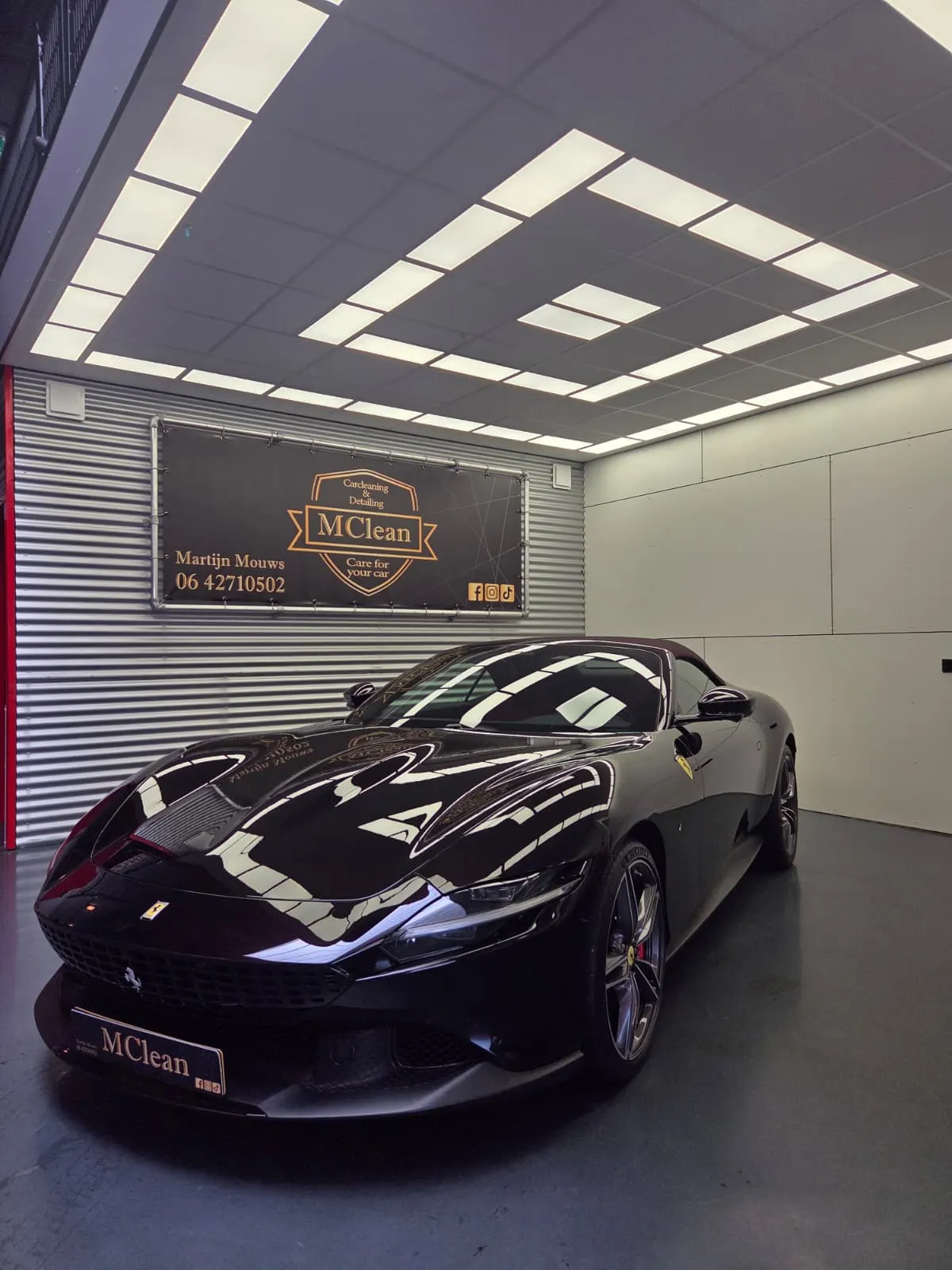 Donkerrode Ferrari Roma Spider onder de studioverlichting