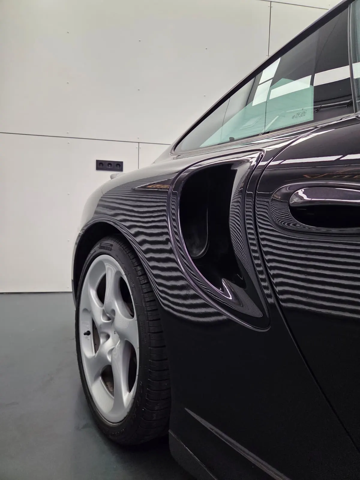 Strakke reflecties in de zwarte lak van een Porsche 911 Turbo