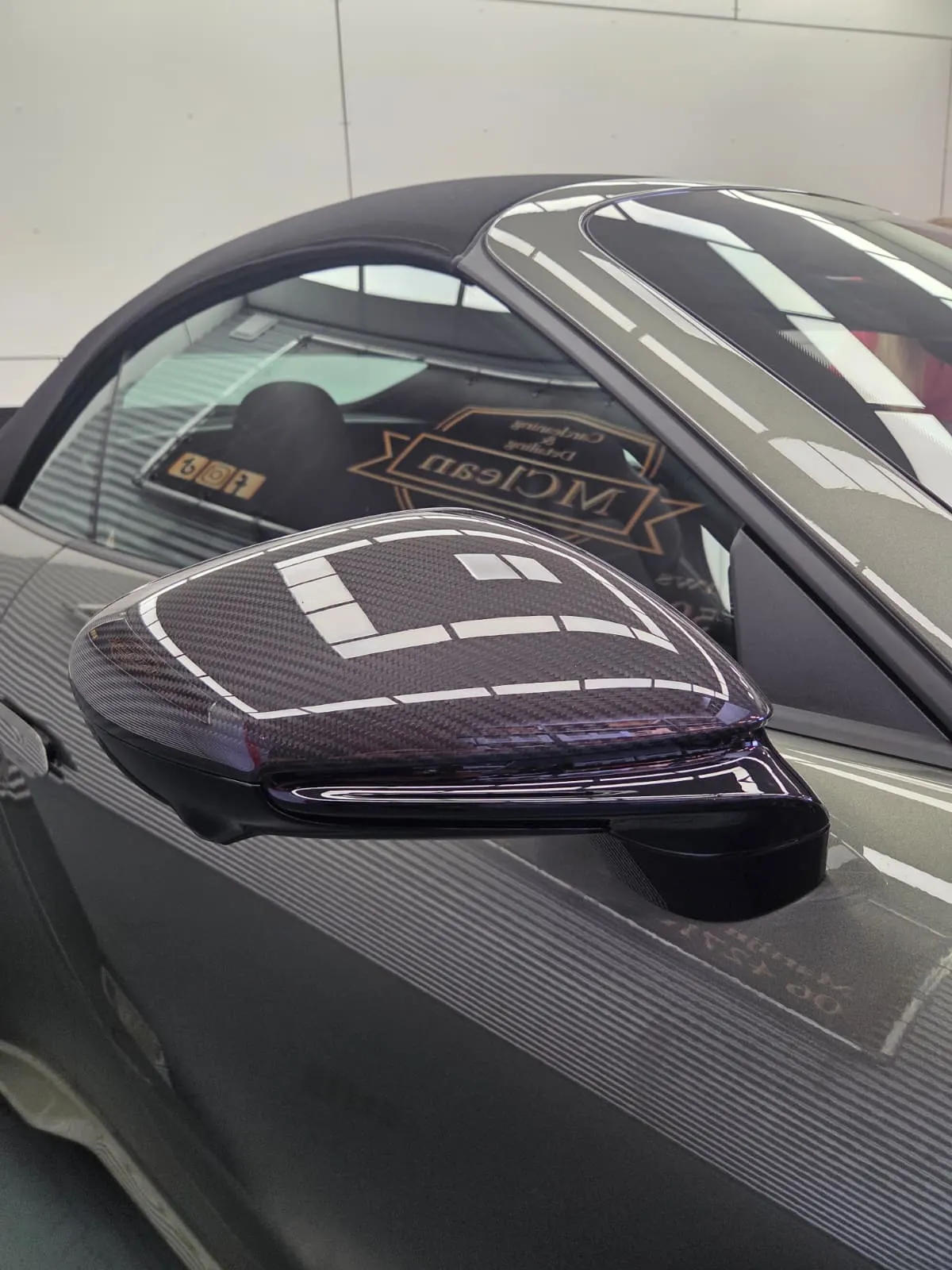 De studio weerspiegelt in de carbon spiegelkap en de zijruit van een Porsche 911