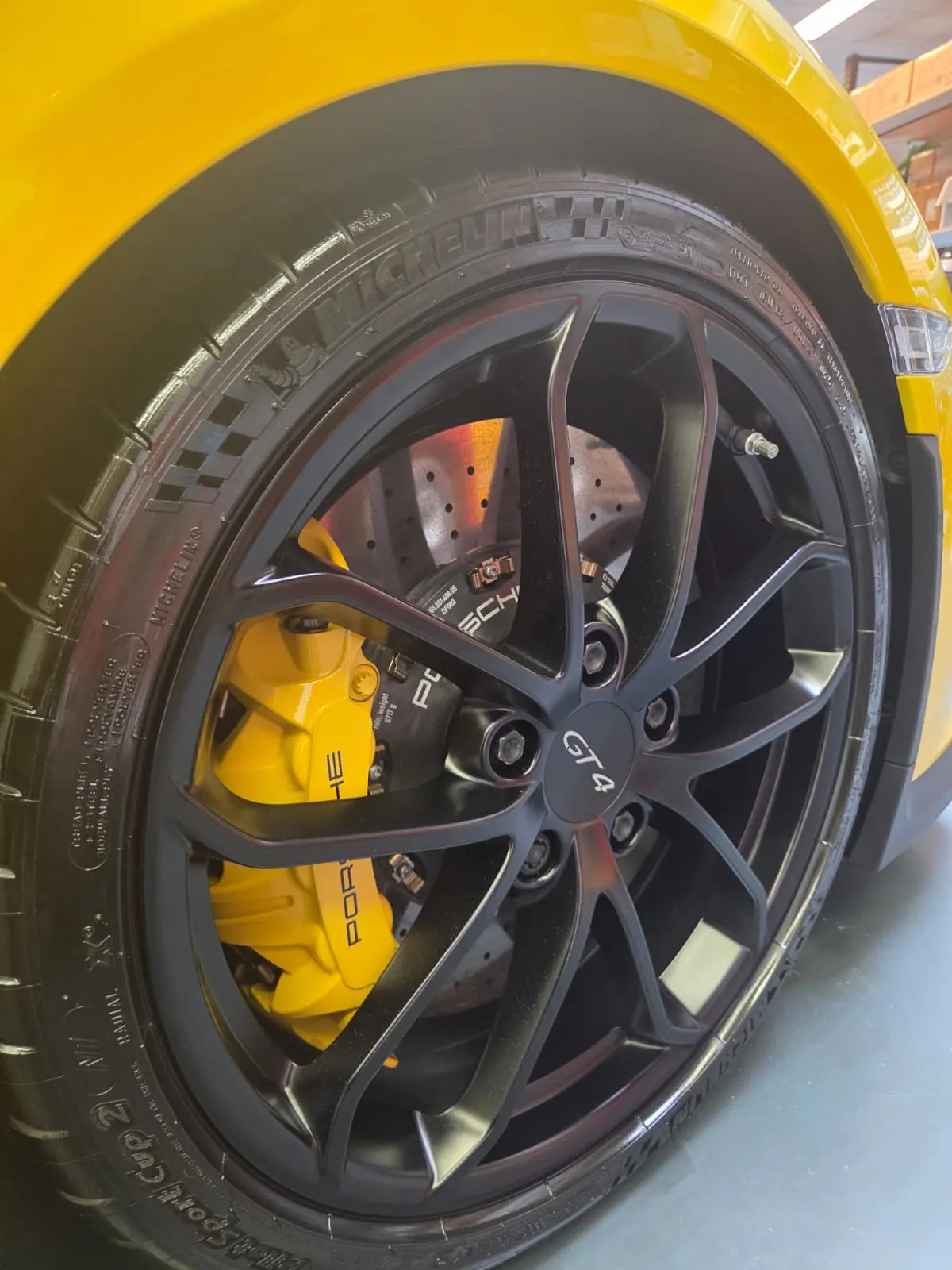 Zwarte velg en gele remklauw van een Porsche Cayman GT4